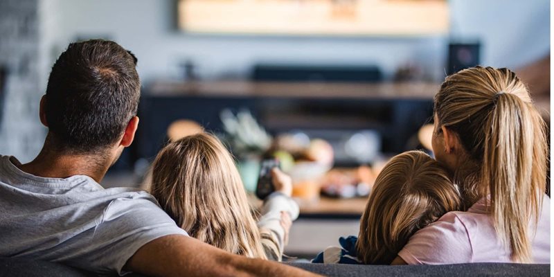 family watching tv on sofa at home