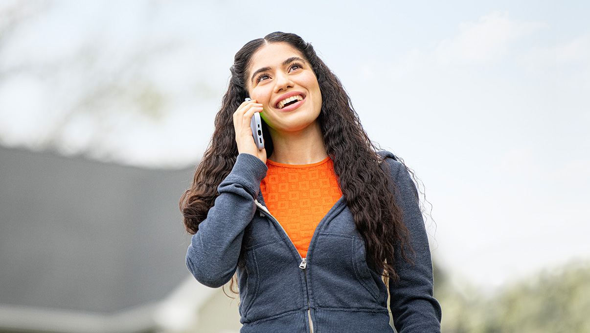 Women outside smiling while on phone using Optimum Mobile