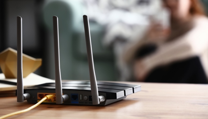 A black modem with a yellow cord plugged into the back of it