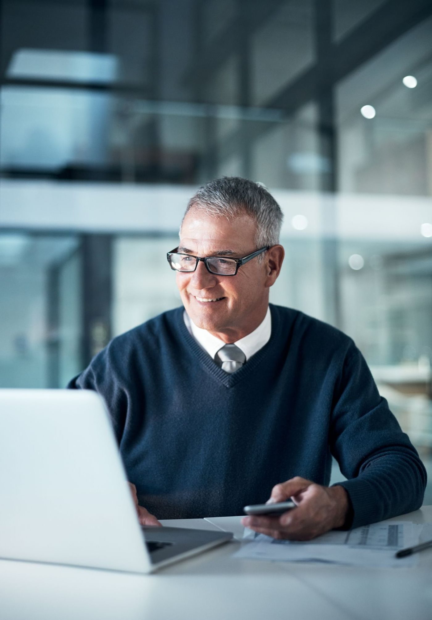 A businessman smiles while working on his laptop