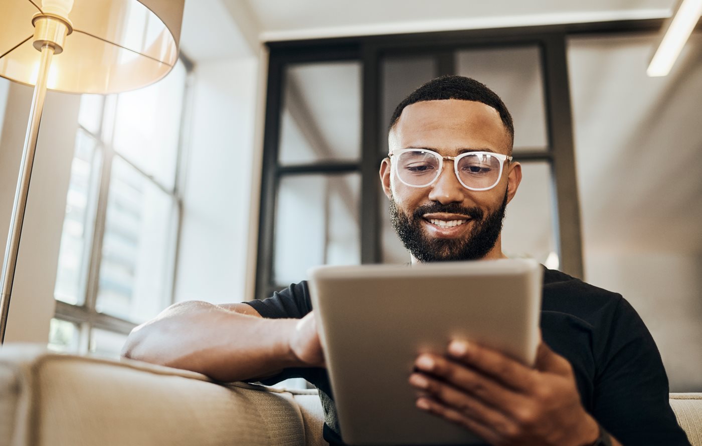 A middle-aged man wearing glasses looks at his ipad while using Cox Internet services