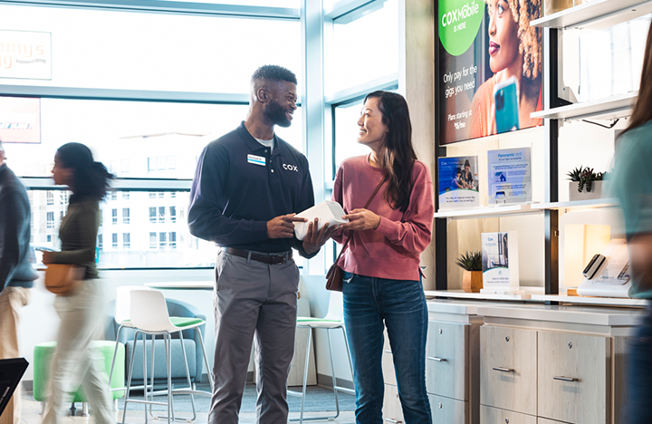 A Cox Mobile employee helps a woman customer in the store